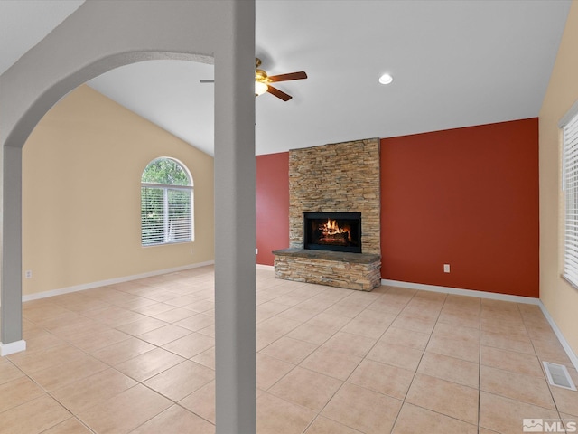 1820 Bogie Ct, Fernley, NV 89408 - unfurnished living room featuring a ceiling fan, arched walkways, light tile patterned flooring, a fireplace, and vaulted ceiling