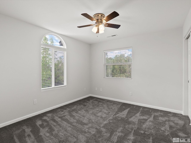 1820 Bogie Ct, Fernley, NV 89408 - spare room featuring healthy amount of natural light, dark carpet, baseboards, and ceiling fan