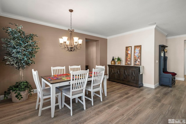 dining space featuring wood finished floors, crown molding, a chandelier, baseboards, and a wood stove