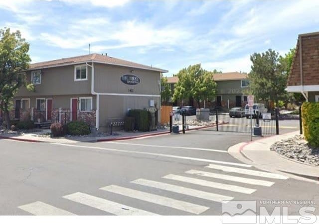 1424 E 9th Unit 2, Reno, NV 89512 - view of asphalt road featuring sidewalks, curbs, a gated entry, and a gate