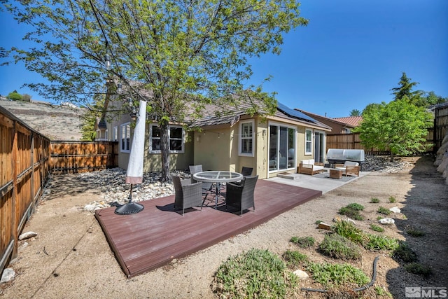 5132 Ironstone Cir, Sparks, NV 89436 - rear view of property featuring an outdoor hangout area, outdoor dining area, a fenced backyard, a deck, and solar panels