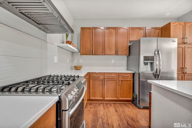 5132 Ironstone Cir, Sparks, NV 89436 - kitchen with stainless steel appliances, ventilation hood, light wood finished floors, light countertops, and backsplash