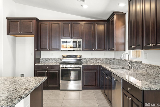 1132 Alder Walk Way, Sparks, NV 89441 - kitchen with appliances with stainless steel finishes, a sink, vaulted ceiling, dark brown cabinetry, and light stone countertops