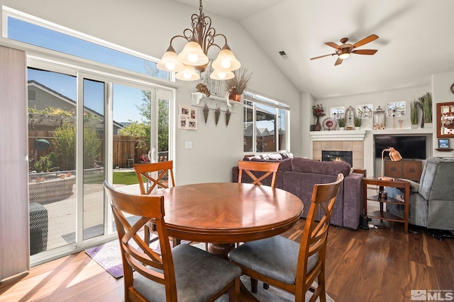 1717 Burwood Cir, Reno, NV 89521 - dining space with wood finished floors, vaulted ceiling, healthy amount of natural light, a tiled fireplace, and ceiling fan