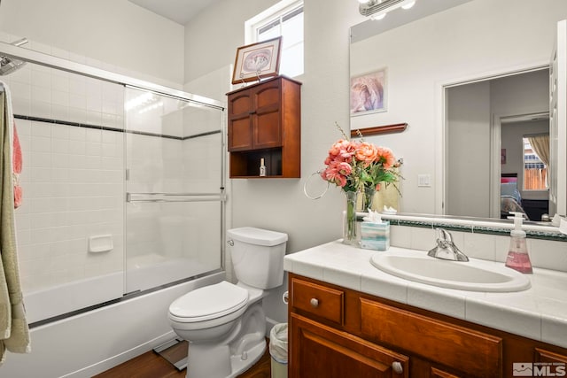 1717 Burwood Cir, Reno, NV 89521 - full bathroom featuring toilet, wood finished floors, bath / shower combo with glass door, and vanity