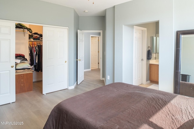 2765 Erin Dr, Sparks, NV 89436 - bedroom featuring light wood-style flooring, a closet, a walk in closet, connected bathroom, and baseboards