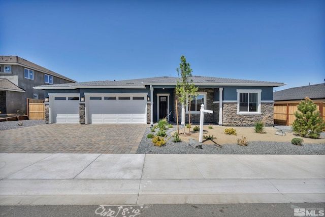 698 Sage Grouse Lp, Gardnerville, NV 89460 - prairie-style house featuring stone siding, driveway, a garage, fence, and stucco siding