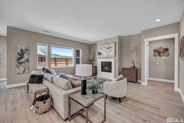 698 Sage Grouse Lp, Gardnerville, NV 89460 - living room featuring light wood-type flooring, baseboards, a glass covered fireplace, and recessed lighting