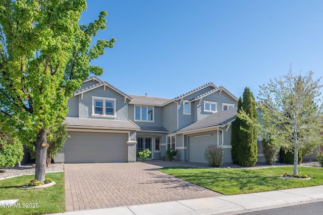 1304 Lambrusca Dr, Sparks, NV 89436 - view of front of house featuring decorative driveway, an attached garage, stucco siding, a front lawn, and a tile roof