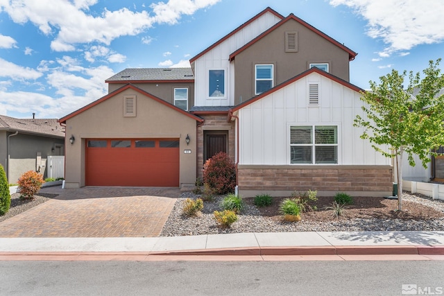 606 Braided Rope Dr, Reno, NV 89511 - view of front of home with board and batten siding, an attached garage, decorative driveway, and stone siding
