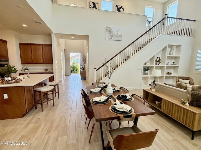 606 Braided Rope Dr, Reno, NV 89511 - dining space with a towering ceiling, light wood-style floors, stairway, and recessed lighting