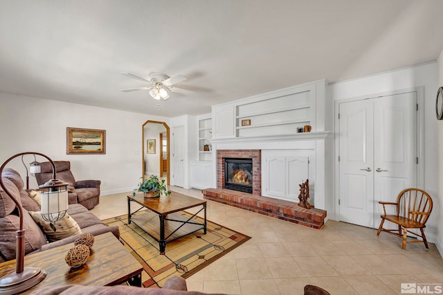 1871 Walnut Ct, Carson City, NV 89703 - living area featuring light tile patterned floors, arched walkways, ceiling fan, a brick fireplace, and baseboards