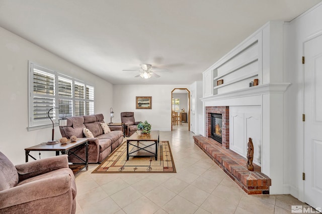 1871 Walnut Ct, Carson City, NV 89703 - living area with light tile patterned floors, ceiling fan, arched walkways, a brick fireplace, and baseboards