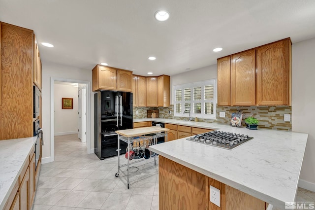 1871 Walnut Ct, Carson City, NV 89703 - kitchen featuring black appliances, a peninsula, tasteful backsplash, recessed lighting, and baseboards