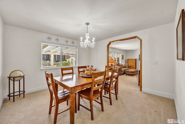 1871 Walnut Ct, Carson City, NV 89703 - dining space with a chandelier, light colored carpet, baseboards, and arched walkways