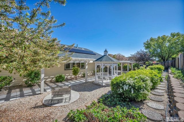 1871 Walnut Ct, Carson City, NV 89703 - rear view of house featuring a gazebo, fence, roof mounted solar panels, and a patio area