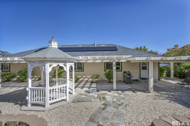 1871 Walnut Ct, Carson City, NV 89703 - rear view of property featuring a patio area, a pergola, roof mounted solar panels, roof with shingles, and a gazebo