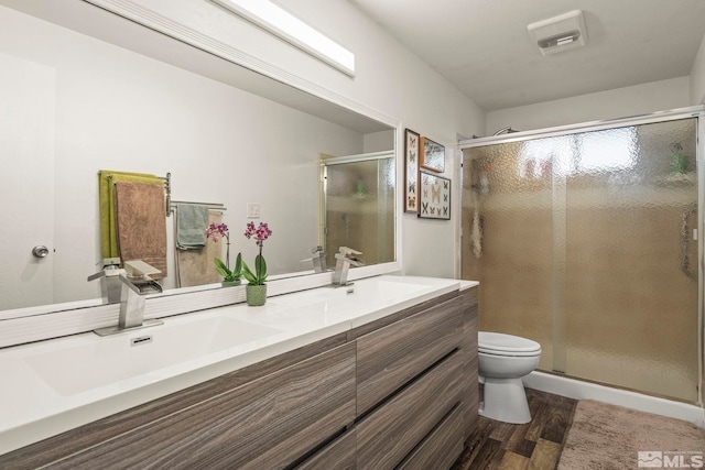 3255 Corey Dr, Reno, NV 89509 - bathroom featuring wood finished floors, toilet, double vanity, and a stall shower