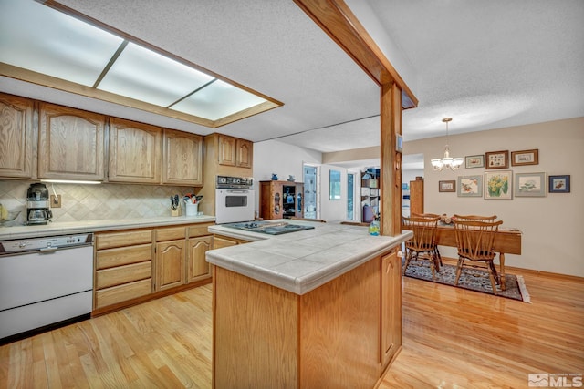 2012 Branch Ln, Reno, NV 89509 - kitchen featuring white appliances, tile countertops, light wood-style floors, decorative backsplash, and a chandelier