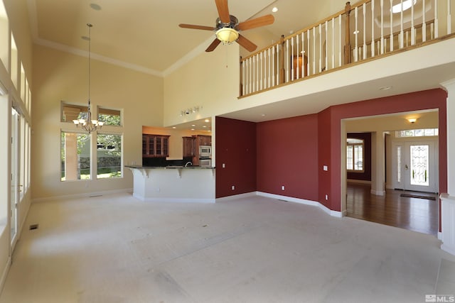 2459 Genoa Highlands, Genoa, NV 89411 - unfurnished living room with a towering ceiling, a chandelier, baseboards, a ceiling fan, and light carpet