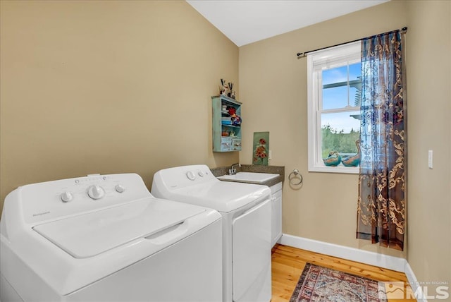 212 Foothill Meadows Ct, Genoa, NV 89411 - laundry area with washer and clothes dryer, light wood-type flooring, baseboards, and cabinet space