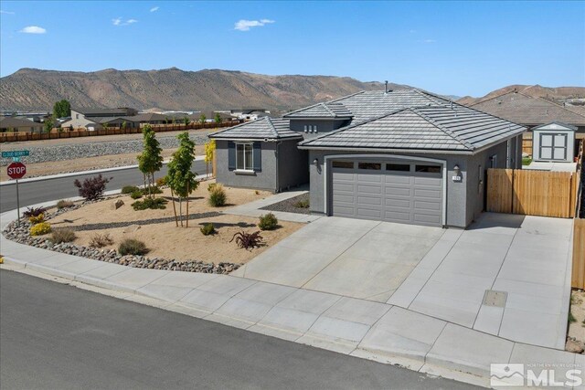 101 Cloud Berry Ct, Sparks, NV 89441 - view of front of house featuring a garage, fence, a mountain view, and driveway