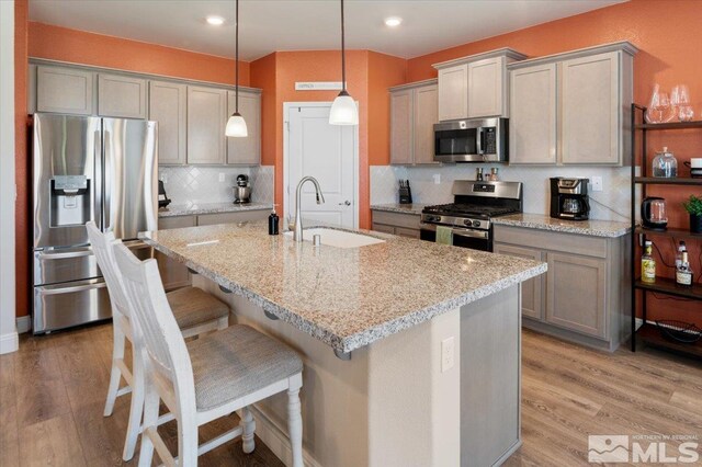 101 Cloud Berry Ct, Sparks, NV 89441 - kitchen with appliances with stainless steel finishes, a sink, gray cabinetry, light wood-type flooring, and backsplash