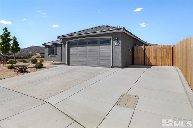 101 Cloud Berry Ct, Sparks, NV 89441 - view of front of home with fence, concrete driveway, an attached garage, a tiled roof, and stucco siding