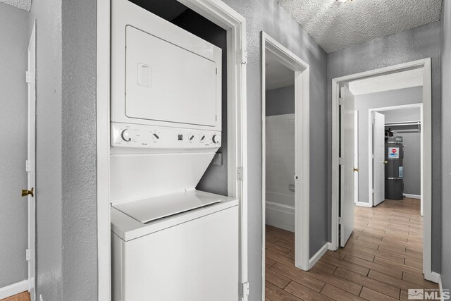 2090 Highview Ct Unit 8, Reno, NV 89512 - washroom with estacked washer and dryer, wood finished floors, a textured ceiling, baseboards, and a textured wall