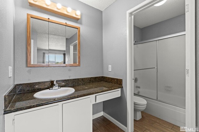 2090 Highview Ct Unit 8, Reno, NV 89512 - bathroom with wood finished floors, vanity, toilet, a textured ceiling, and shower / bath combination with glass door