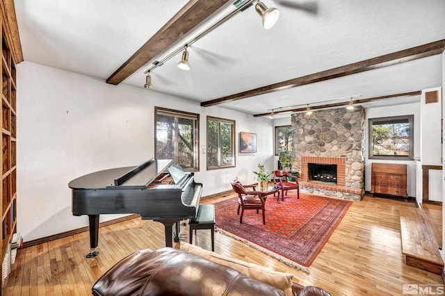 2820 Sagittarius Dr, Reno, NV 89509 - living room featuring track lighting, baseboards, hardwood / wood-style flooring, beamed ceiling, and a brick fireplace