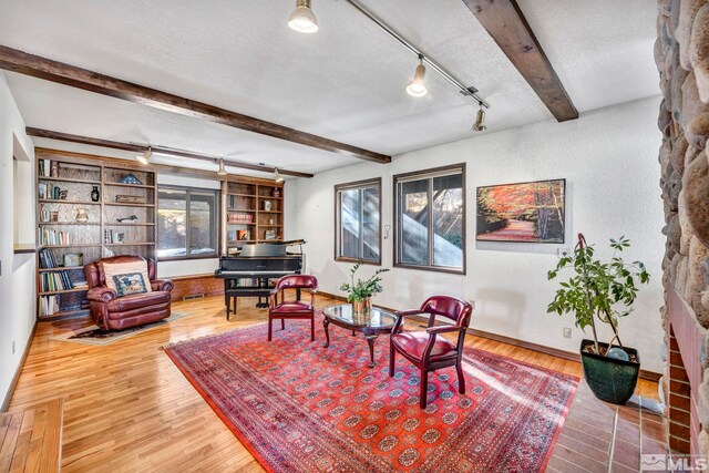 2820 Sagittarius Dr, Reno, NV 89509 - living area featuring beam ceiling, hardwood / wood-style floors, baseboards, track lighting, and a textured wall