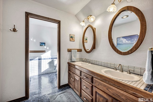 2820 Sagittarius Dr, Reno, NV 89509 - bathroom featuring double vanity, tile patterned flooring, baseboards, and a textured wall