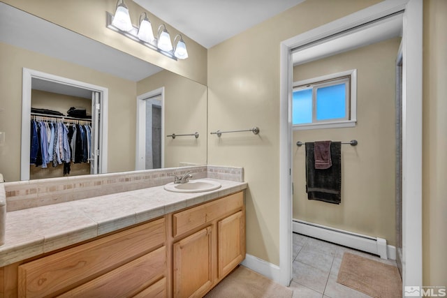 3295 Sunnyvale Ave, Reno, NV 89509 - full bathroom featuring baseboard heating, tile patterned flooring, baseboards, a walk in closet, and vanity