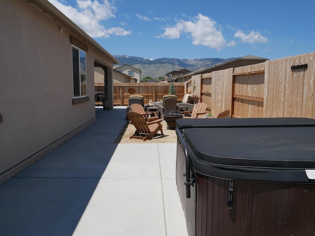 1848 Boundary Peak St, Carson City, NV 89701 - view of patio / terrace with a hot tub, a fenced backyard, a mountain view, and a fire pit