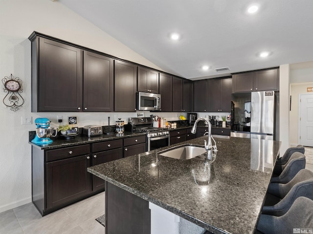 359 Bryce St, Dayton, NV 89403 - kitchen with appliances with stainless steel finishes, a sink, dark brown cabinetry, a kitchen bar, and lofted ceiling