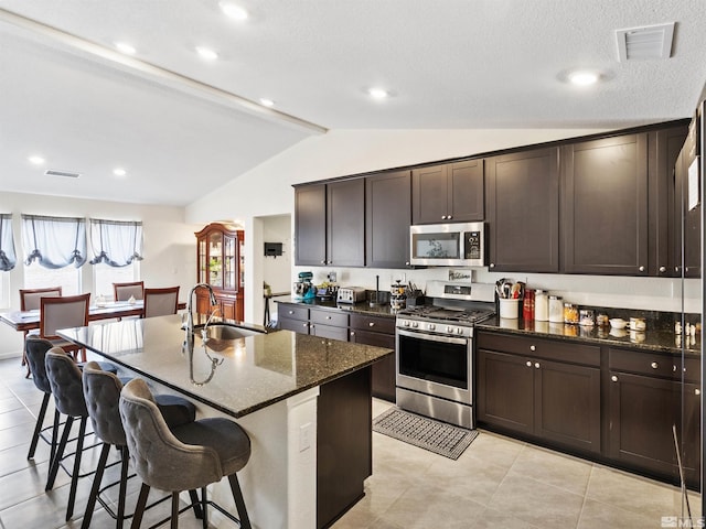 359 Bryce St, Dayton, NV 89403 - kitchen with appliances with stainless steel finishes, a sink, dark stone countertops, a kitchen breakfast bar, and dark brown cabinetry