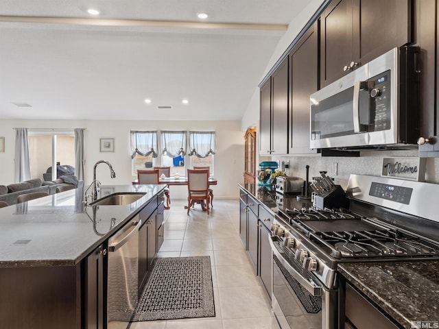 359 Bryce St, Dayton, NV 89403 - kitchen with stainless steel appliances, a sink, dark brown cabinetry, dark stone countertops, and recessed lighting