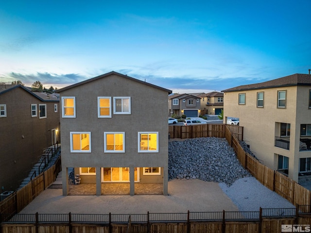 back of property featuring a fenced backyard, a patio, stucco siding, and a residential view