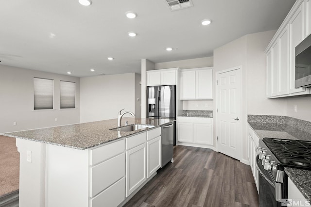 kitchen with stainless steel appliances, a sink, recessed lighting, stone countertops, and dark wood-type flooring