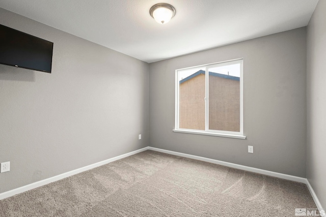 empty room featuring carpet floors and baseboards