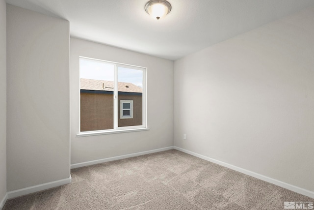 unfurnished room with carpet flooring and baseboards
