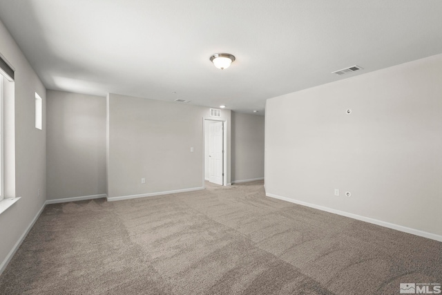 spare room with light colored carpet and baseboards