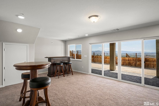 sitting room featuring carpet floors, a dry bar, recessed lighting, and baseboards