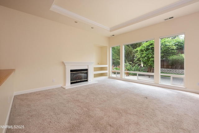 706 Norfolk Dr, Carson City, NV 89703 - unfurnished living room featuring a raised ceiling, ornamental molding, healthy amount of natural light, a glass covered fireplace, and carpet