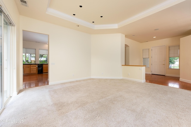 706 Norfolk Dr, Carson City, NV 89703 - unfurnished living room featuring carpet floors, a raised ceiling, plenty of natural light, ornamental molding, and arched walkways