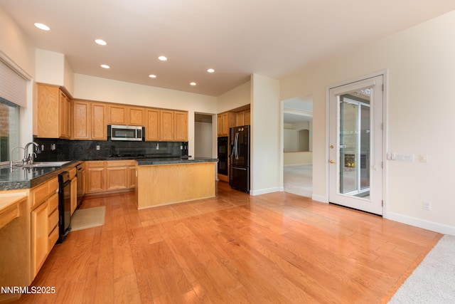 706 Norfolk Dr, Carson City, NV 89703 - kitchen with black appliances, decorative backsplash, a center island, recessed lighting, and light wood-style flooring