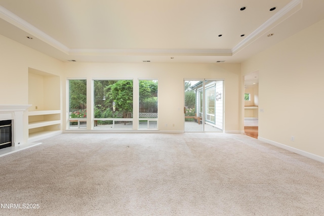 706 Norfolk Dr, Carson City, NV 89703 - unfurnished living room with a tray ceiling, crown molding, a glass covered fireplace, light colored carpet, and built in shelves