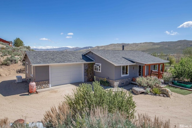 14865 N Red Rock Rd, Reno, NV 89508 - ranch-style home with stone siding, a mountain view, driveway, and a garage