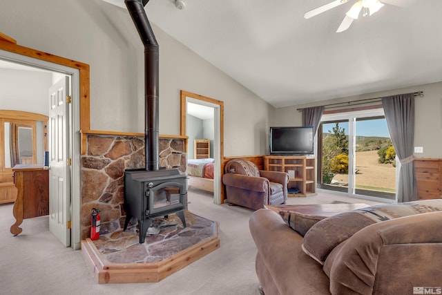 14865 N Red Rock Rd, Reno, NV 89508 - living area featuring a wood stove, lofted ceiling, light colored carpet, a wainscoted wall, and a ceiling fan